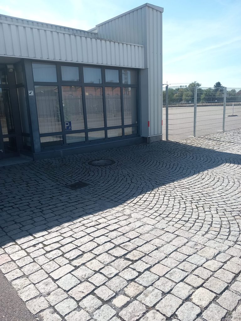Gepflasterter Eingangsbereich mit Glasfront nach der Außenreinigung bei Grammer