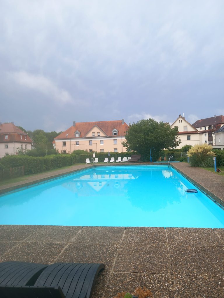 Gepflegte Außenanlage mit Schwimmbecken, Liegen und Hecken am Bildungshaus St. Bernhard