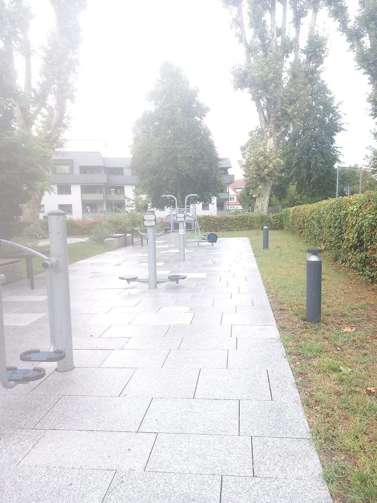 Gepflegte Fitnessanlage im Freien mit Granitplatten und Rasenfläche
